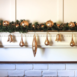 Gold Christmas ornaments on a mantel