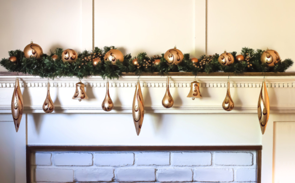 Gold Christmas ornaments on a mantel