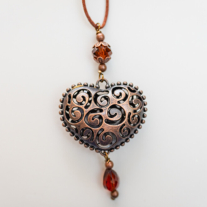 Copper heart-shaped pendant with red color beads