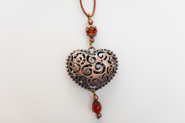 Copper heart-shaped pendant with red color beads