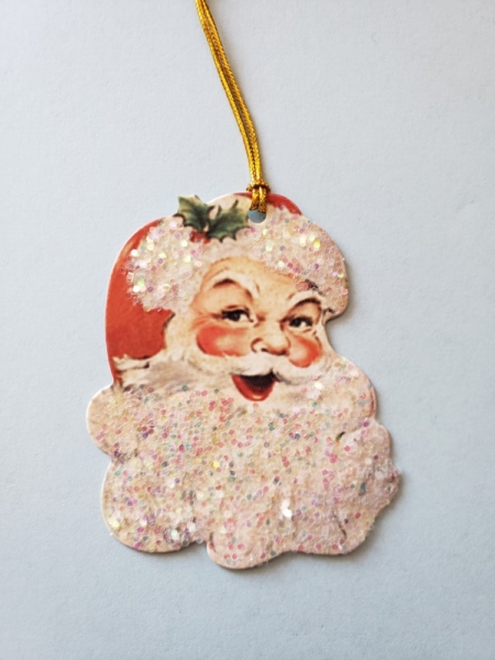 A glittery santa face with gold color hanging