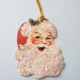 A glittery santa face with gold color hanging