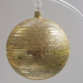 A closeup shot of a glittery gold ball hanging on a stand