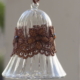 A long Egyptian Glass Crystal bell with a brown lace band