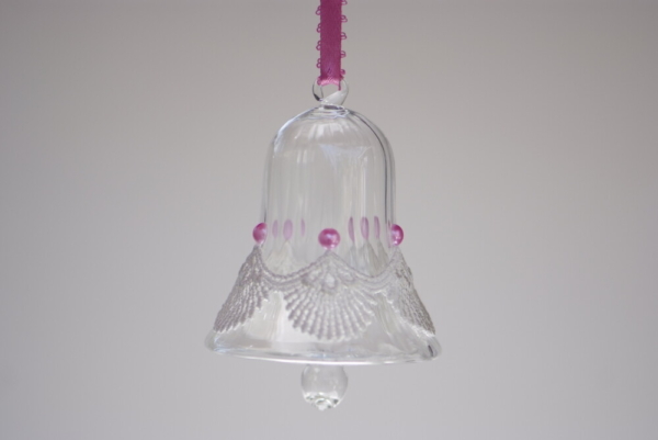 A crystal bell with white fancy lace and pink beads