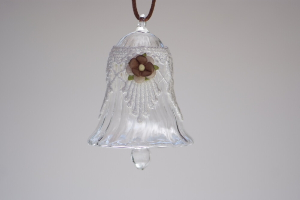 A crystal bell with white fancy lace and brown flower